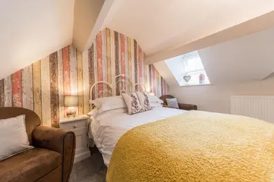 a bedroom with a bed and a couch and a window at Jacksons CafeBar & Guesthouse in Grasmere