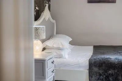 a bedroom with a white bed and a night stand at Jacksons CafeBar & Guesthouse in Grasmere