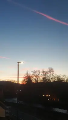 a sunset with a street light in a parking lot at Babbling Brook Guesthouse in Keswick