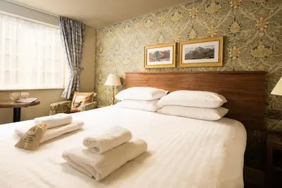 a bedroom with a large white bed with towels on it at The Pheasant Inn - The Inn Collection Group in Bassenthwaite