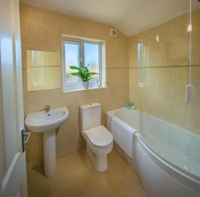 a bathroom with a toilet and a sink and a bath tub at The Garden Apartment in Keswick