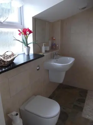 a bathroom with a white toilet and a sink at At Cedar Lodge in Ramsey