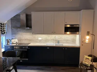 a kitchen with black and white cabinets and a sink at Amadeus Apartments in Douglas