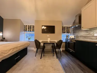 a bedroom with a bed and a table with chairs at Amadeus Apartments in Douglas