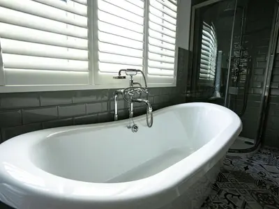 a white bath tub in a bathroom with a window at Amadeus Apartments in Douglas