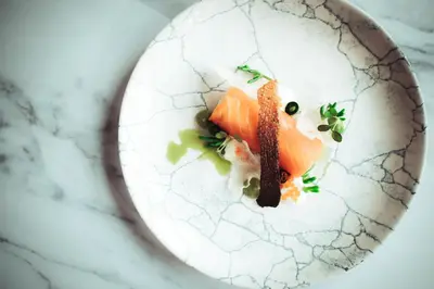 a plate of food with a piece of fish on it at The Ruddings in Keswick