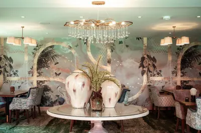 a dining room with a vase on a table with a mural at The Ruddings in Keswick