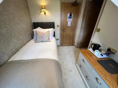 a small bedroom with a bed and a dresser at The Ruddings in Keswick