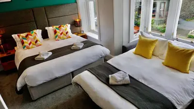 two beds sitting next to each other in a room at Greystoke House in Keswick