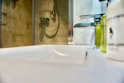 a white sink in a bathroom with a shower at Greystoke House in Keswick