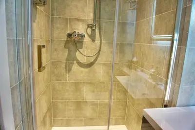 a bathroom with a shower with a glass door at Greystoke House in Keswick