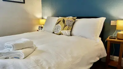 a white bed with pillows and towels on it at Greystoke House in Keswick