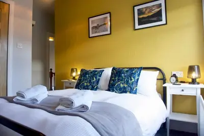 a bedroom with a white bed with towels on it at Greystoke House in Keswick