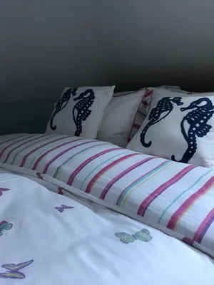 a bed with two pillows with mermaid patterns on it at The Toll House in Newton Stewart
