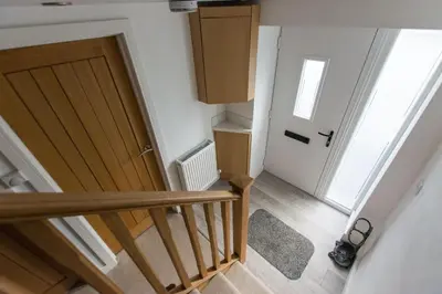 an empty hallway with a staircase and a door at Red Rose Cottage in Cockermouth