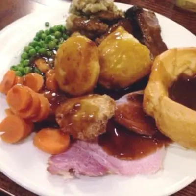 a plate of food with meat vegetables and peas at Red Rose Cottage in Cockermouth