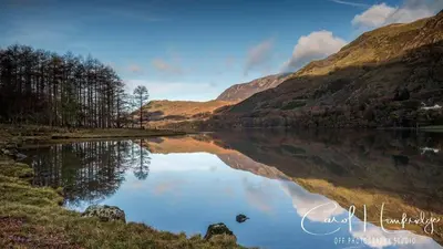 a lake in the middle of a valley with mountains at Red Rose Cottage in Cockermouth