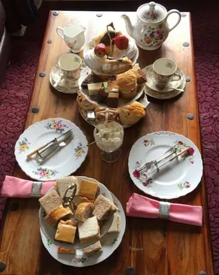 a wooden table with plates of food on it at Bakers Cottage in Cockermouth