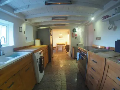 a kitchen with a sink and a washing machine at Rivendell Cottage in Douglas