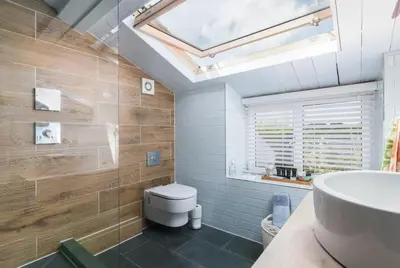 a bathroom with a white toilet and a sink at Rivendell Cottage in Douglas
