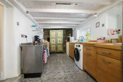 a large kitchen with a washer and dryer in it at Rivendell Cottage in Douglas