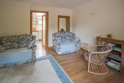 a living room with a couch and a chair at Woodcroft Cottage in Ayr