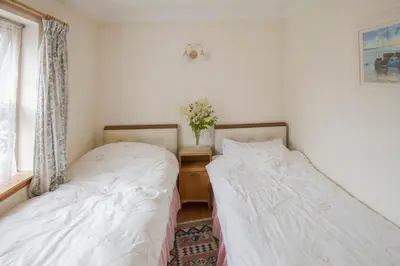 two beds sitting next to each other in a bedroom at Woodcroft Cottage in Ayr