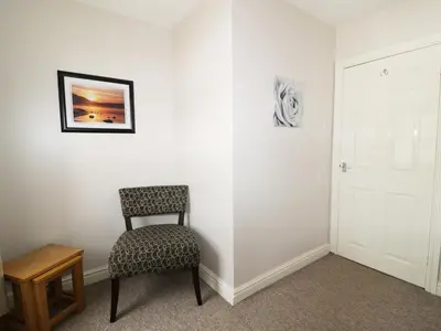a chair sitting in a room with a white wall at William Court Cottage in Santon Bridge