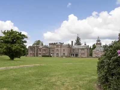 a large building with a large field of grass at William Court Cottage in Santon Bridge