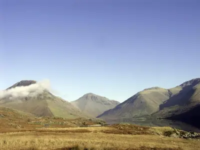 a mountain range with a body of water in a field at William Court Cottage in Santon Bridge