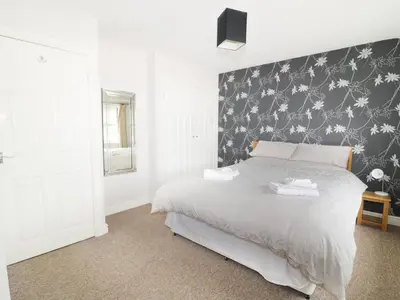 a bedroom with a bed with a black and white wall at William Court Cottage in Santon Bridge