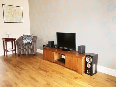 a living room with a flat screen tv and speakers at William Court Cottage in Santon Bridge