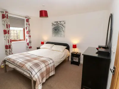 a bedroom with a bed and a television in it at Nuthatch in Ivegill