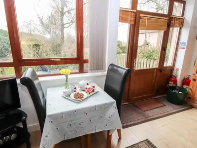 a table with a plate of food on it in front of a window at Nuthatch in Ivegill
