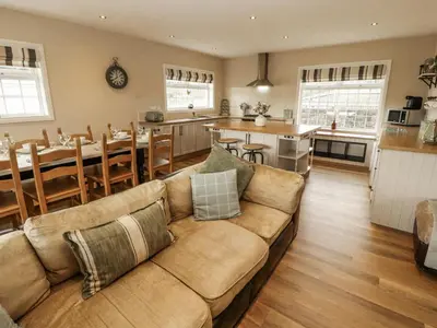 a living room with a couch and a kitchen at White Gables in Great Clifton