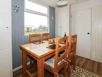 a dining room with a wooden table and chairs at Kouloura in Mainsriddle