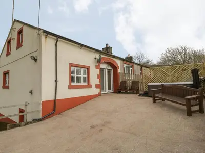 a building with a bench in front of it at Bleng Barn Cottage in Seascale