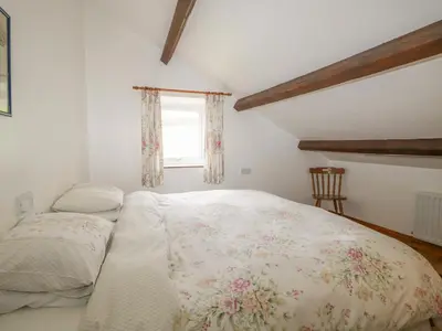 a bedroom with a bed and a window at Bleng Barn Cottage in Seascale
