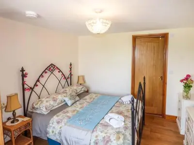 a bedroom with a bed and a chandelier at Muncaster View in Drigg