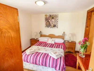 a bedroom with two beds and a table with flowers at Muncaster View in Drigg