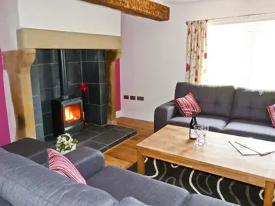 a living room with a couch and a fireplace at Chimney Gill in Sebergham