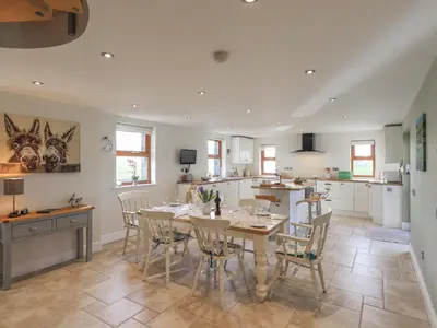 a kitchen and dining room with a table and chairs at South Milton Cottage in Glenluce