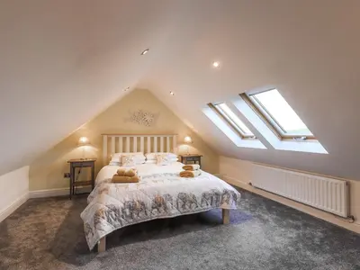 a bedroom with a bed with two teddy bears on it at South Milton Cottage in Glenluce