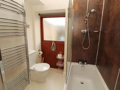 a bathroom with a tub and a toilet and a shower at The Old Bothy in Wigton