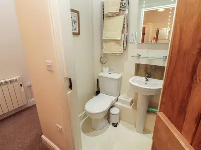 a small bathroom with a toilet and a sink at The Old Grainstore in Wigton