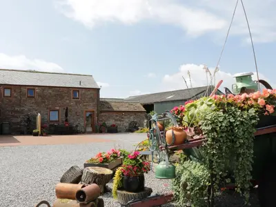 a display of flowers and plants in front of a building at Piggery Cottage in Wigton