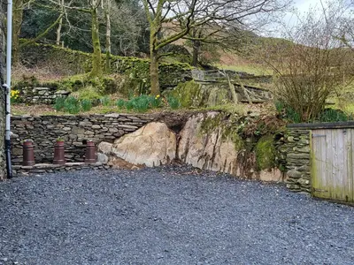 a stone wall next to a stone fence at High Kiln Bank Cottage in Ulpha