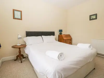 a bedroom with a large white bed and a table at Peel Place Noddle in Eskdale