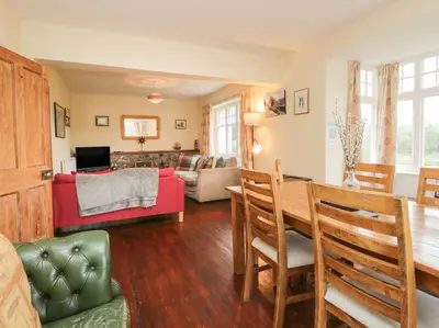 a dining room and living room with a table and chairs at Peel Place Noddle in Eskdale