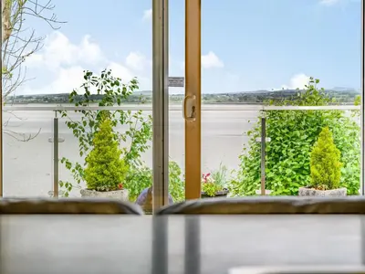 a room with a view of a window with plants at Solway Cottage in Bowness-on-Solway